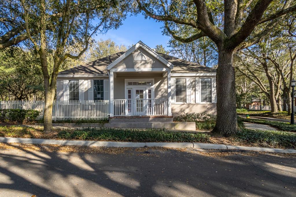 A single-story building with a white porch, picket fence, and large trees in the yard — 5213 & 5217 & 5231 SW 91ST DRIVE, GAINESVILLE, FL
