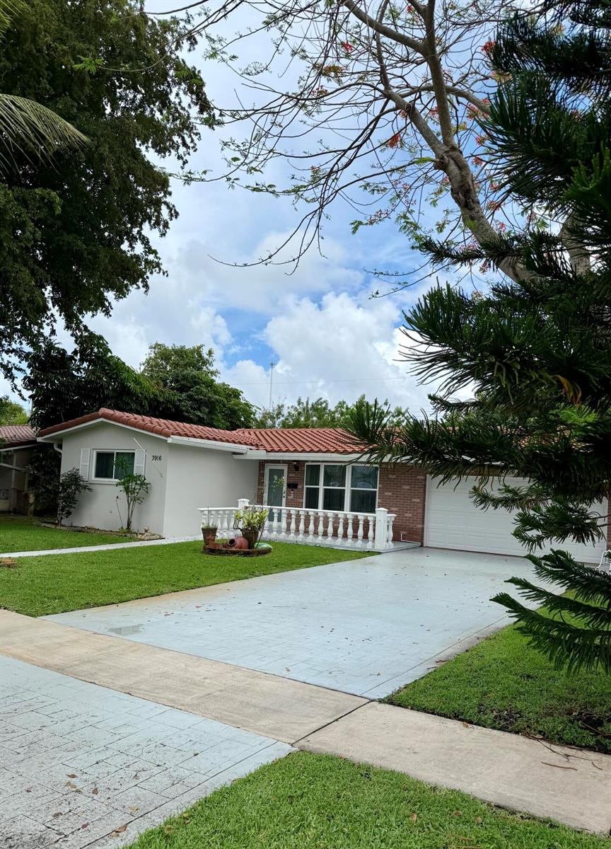 A single-story house with a white stucco exterior, red tile roof, and a paved driveway — 3916 Adams Street, Hollywood FL 33021, HOLLYWOOD, FL