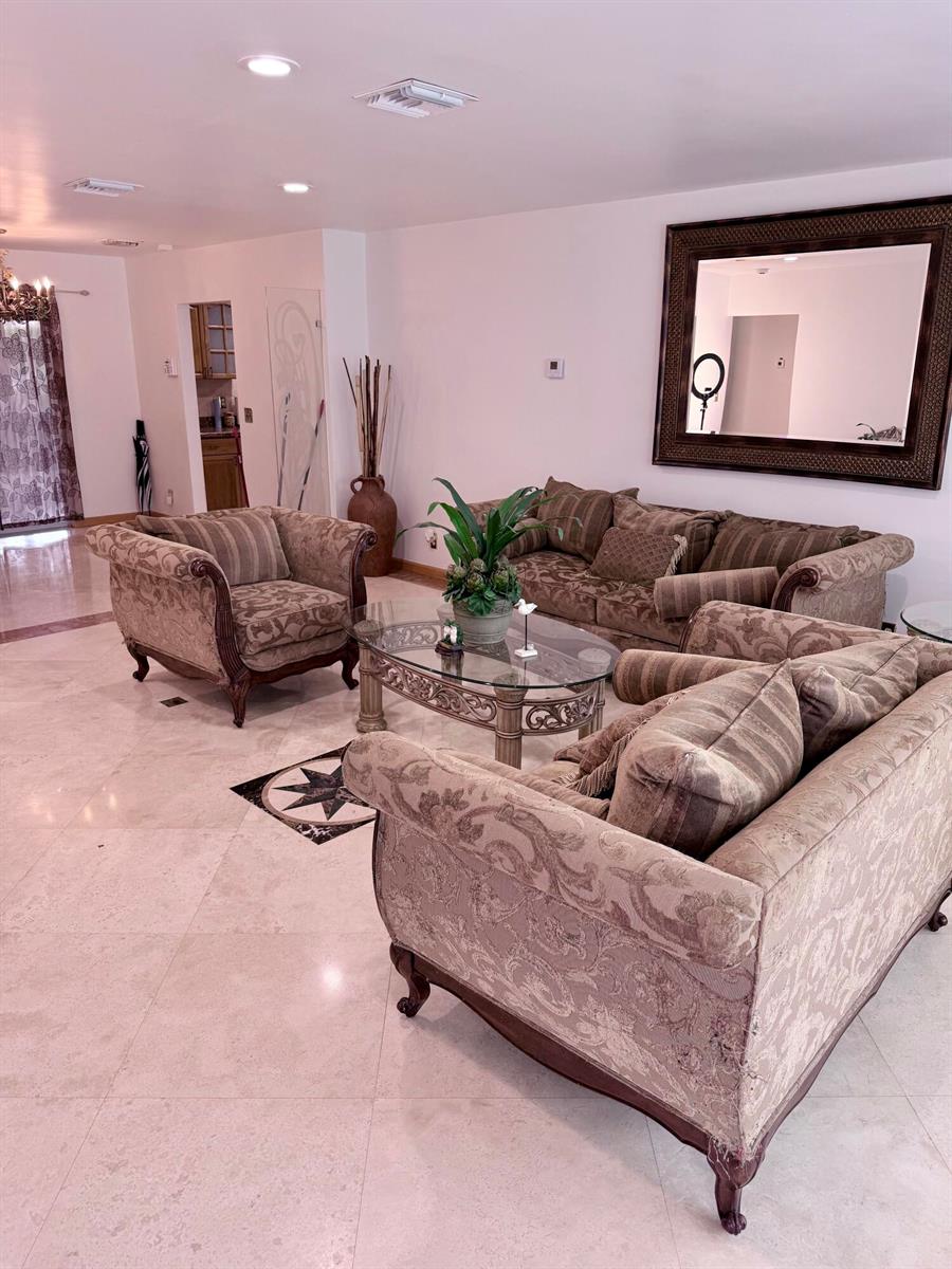 A living room features a matching sofa set, a glass coffee table, and a large mirror — 3916 Adams Street, Hollywood FL 33021, HOLLYWOOD, FL