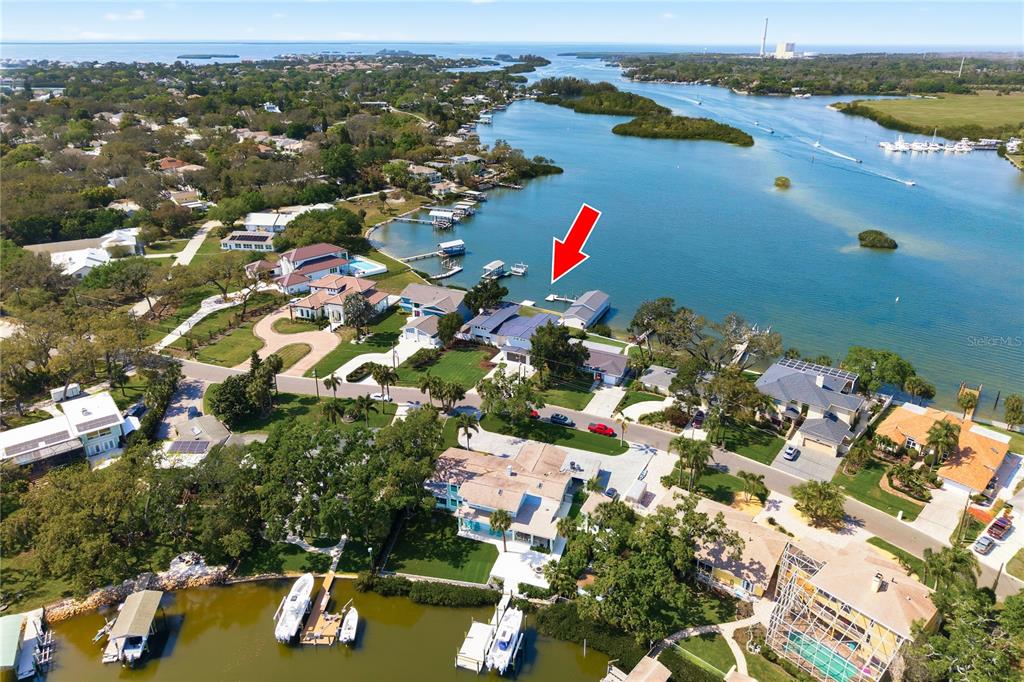 An aerial view shows a waterfront residential property with a private dock and boat lift — 915 BAYSHORE DRIVE, TARPON SPRINGS, FL
