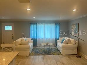 A living room with two white sofas, a coffee table, and a front door — 196 OVERBROOK DRIVE E, LARGO, FL