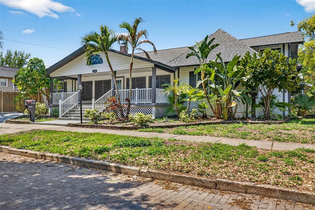 A single-story house with a covered front porch, palm trees, and a brick-paved street — 1330 CHERRY STREET NE, ST PETERSBURG, FL