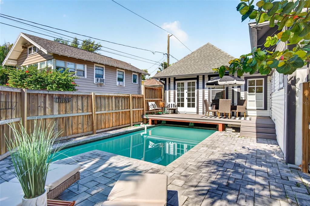 A backyard features a rectangular swimming pool, a wood deck, and a paved patio area — 1330 CHERRY STREET NE, ST PETERSBURG, FL