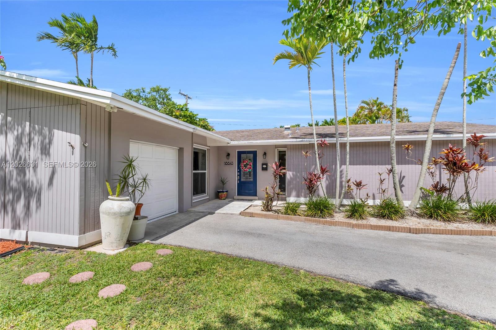 A single-story house features a gray exterior, a blue front door, and a paved driveway — 18645 SW 90th Ave, Cutler Bay FL 33157, CUTLER BAY, FL