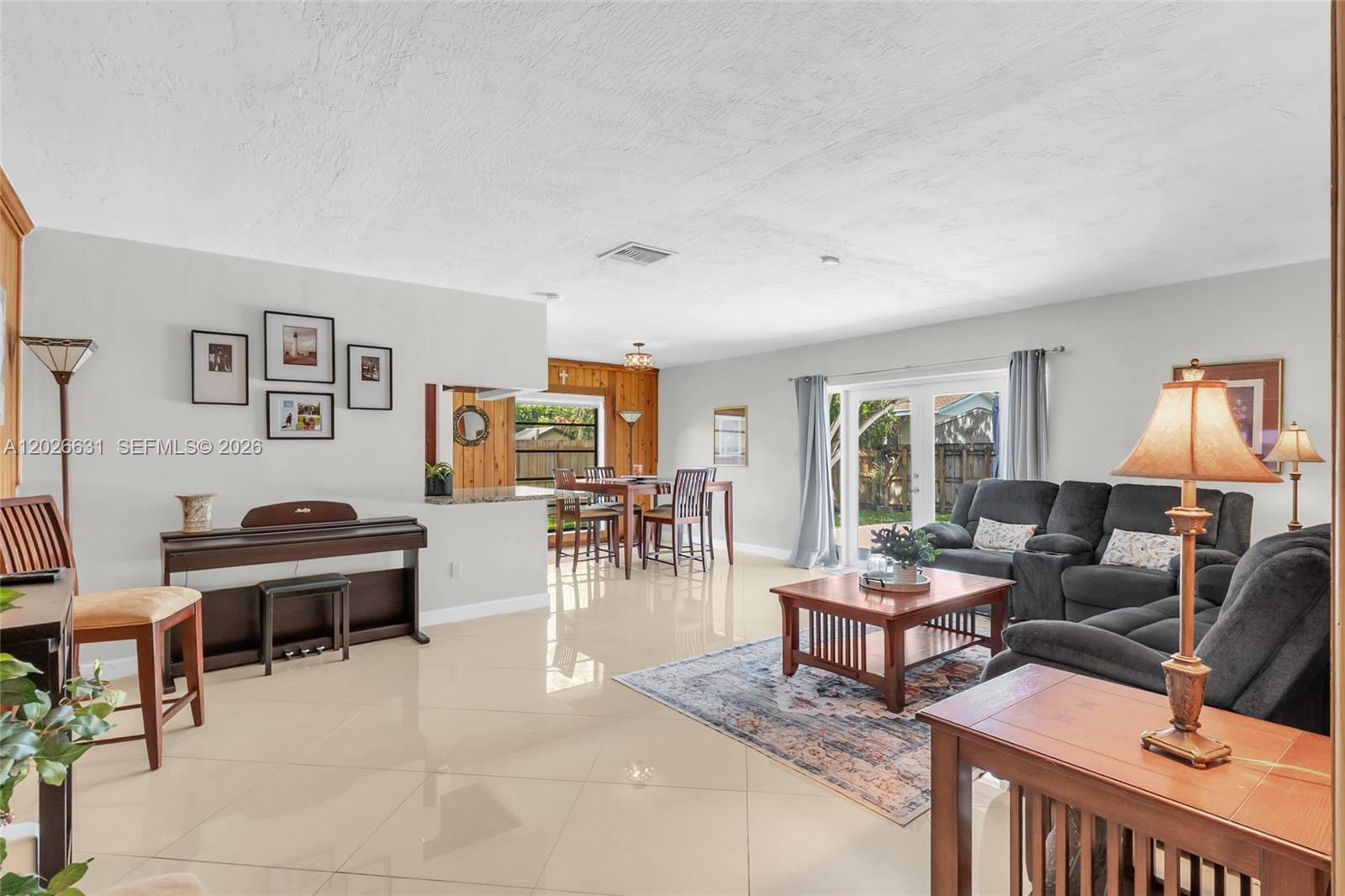 A bright, open-concept living and dining area features light tile floors and neutral walls — 18645 SW 90th Ave, Cutler Bay FL 33157, CUTLER BAY, FL