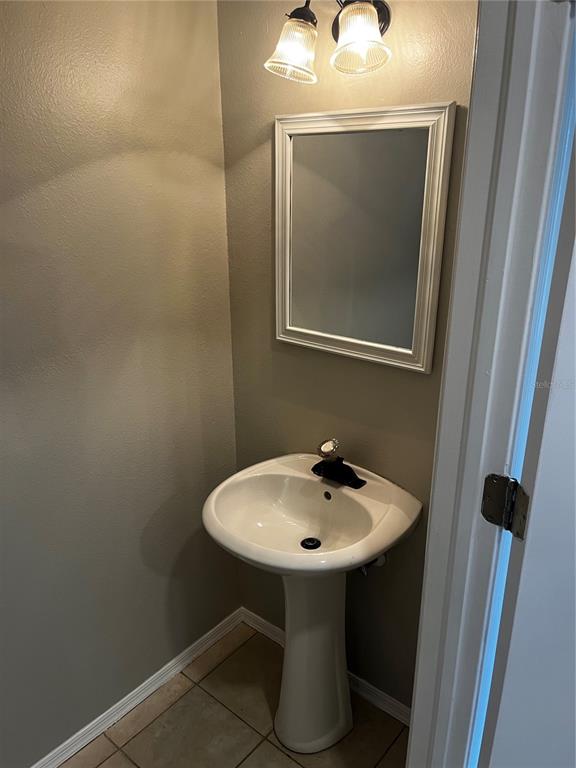 A small bathroom features a white pedestal sink, a rectangular mirror, and two light fixtures — 331 COUNTRYSIDE KEY BOULEVARD, OLDSMAR, FL