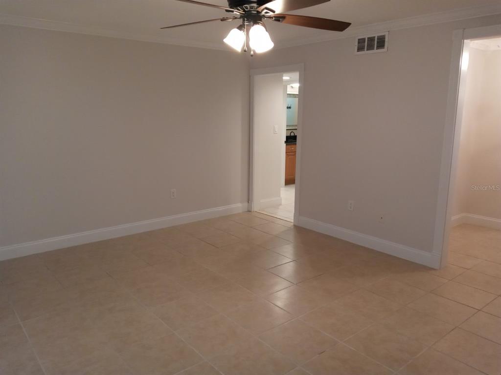 An interior room with light-colored tile flooring, a ceiling fan, and a doorway leading elsewhere — 536 ORANGE DRIVE UNIT 14, ALTAMONTE SPRINGS, FL