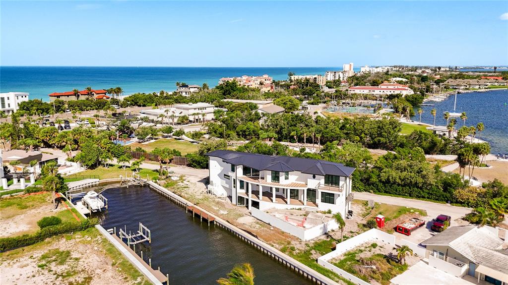 An aerial view shows a modern white house situated along a canal near the ocean — 530 JESSMYTH DRIVE, LONGBOAT KEY, FL