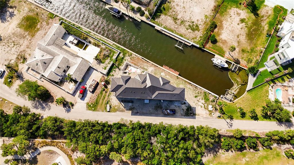 An aerial view shows two houses situated along a canal with a boat docked nearby — 530 JESSMYTH DRIVE, LONGBOAT KEY, FL