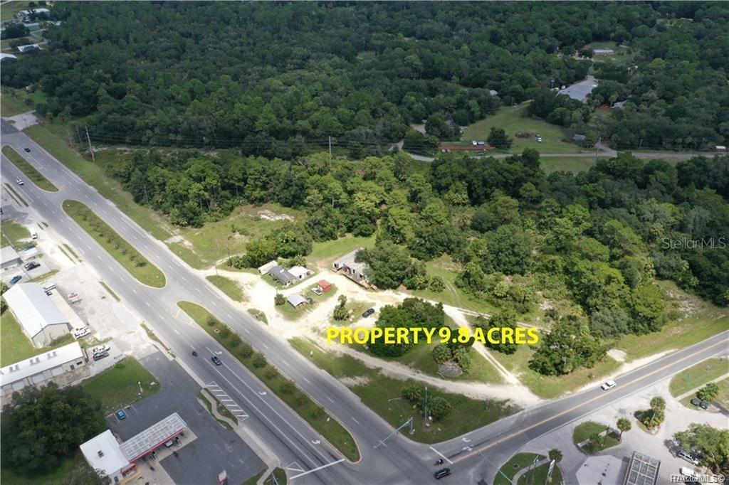 An aerial view shows a large, wooded plot of land with several structures near roads — 3, 9, 17 HWY 19 N, INGLIS, FL