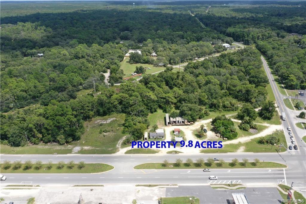 An aerial view shows a 9.8-acre wooded lot with structures located along a multi-lane road — 3, 9, 17 HWY 19 N, INGLIS, FL