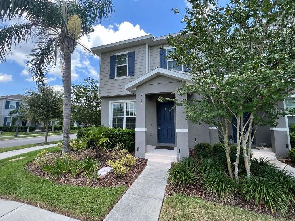 A two-story house exterior features gray siding, blue shutters, and a covered front entryway — 6131 ELFIN HERB WAY, WINTER GARDEN, FL