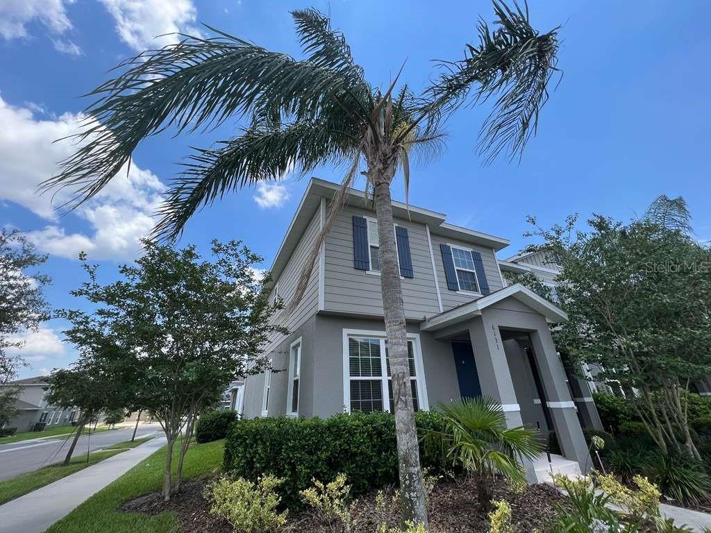 An aerial view shows a multi-unit townhouse building with a red arrow pointing to it — 6131 ELFIN HERB WAY, WINTER GARDEN, FL