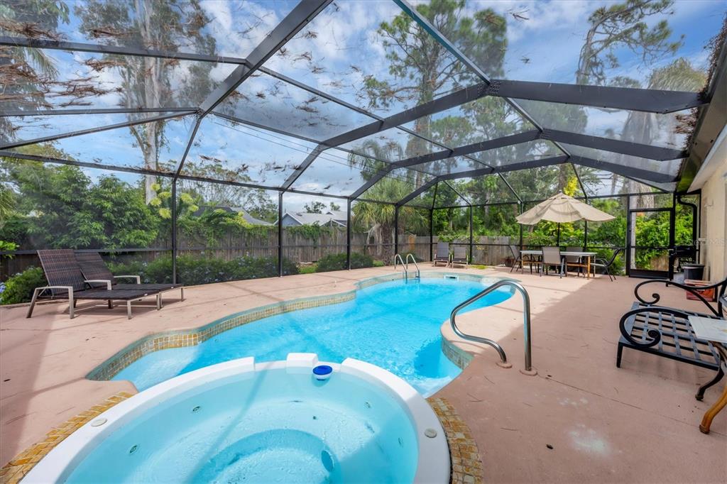 A screened-in patio features a swimming pool, a hot tub, and outdoor furniture — 2445 APACHE STREET, SARASOTA, FL
