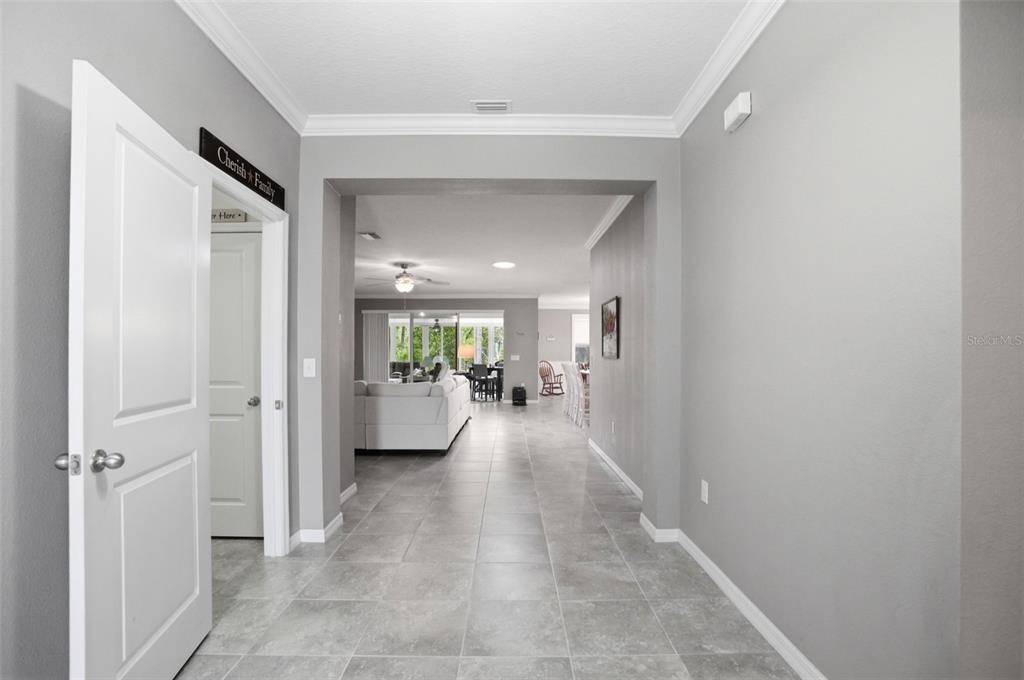 A tiled entryway leads into an open-concept living area with gray walls and white trim — 13897 BLYTHEWOOD DRIVE, SPRING HILL, FL