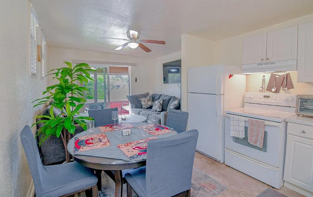 A dining area with a round table and chairs sits adjacent to a white kitchen — 358 1ST AVENUE N, LAKE WALES, FL