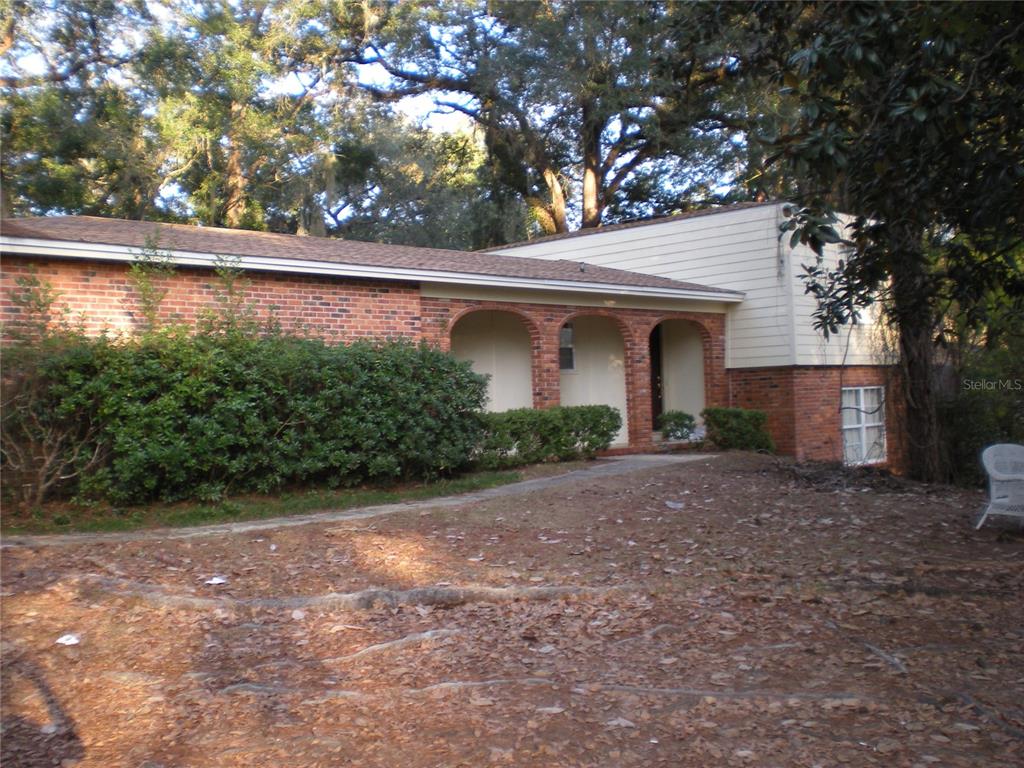 A brick and siding house features a covered porch with three arched openings — 1919 NANTICOKE CIRCLE, TALLAHASSEE, FL