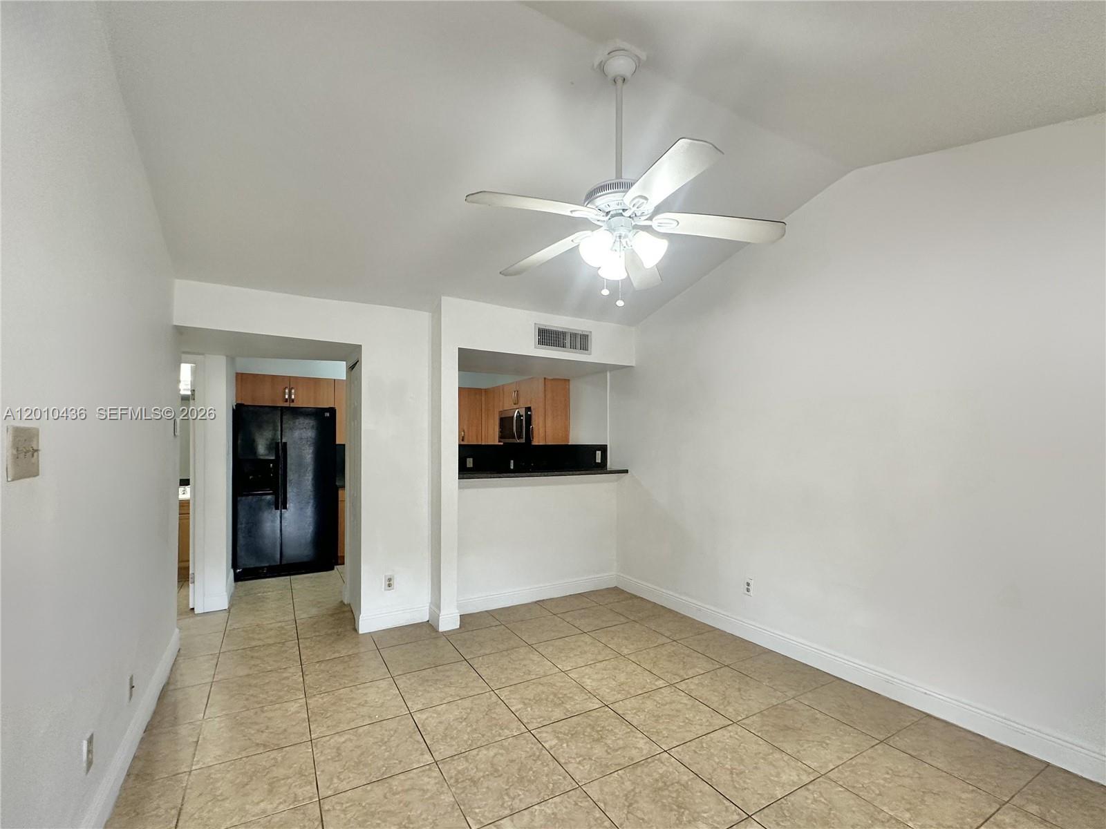 A tiled dining area features a ceiling fan and a pass-through window to the kitchen — 15300 SW 106th Ter # 506, Miami FL 33196, MIAMI, FL