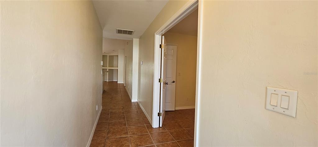 A hallway with tile flooring leads to an open doorway and a room beyond — 3007 SW SANTA BARBARA PLACE, CAPE CORAL, FL