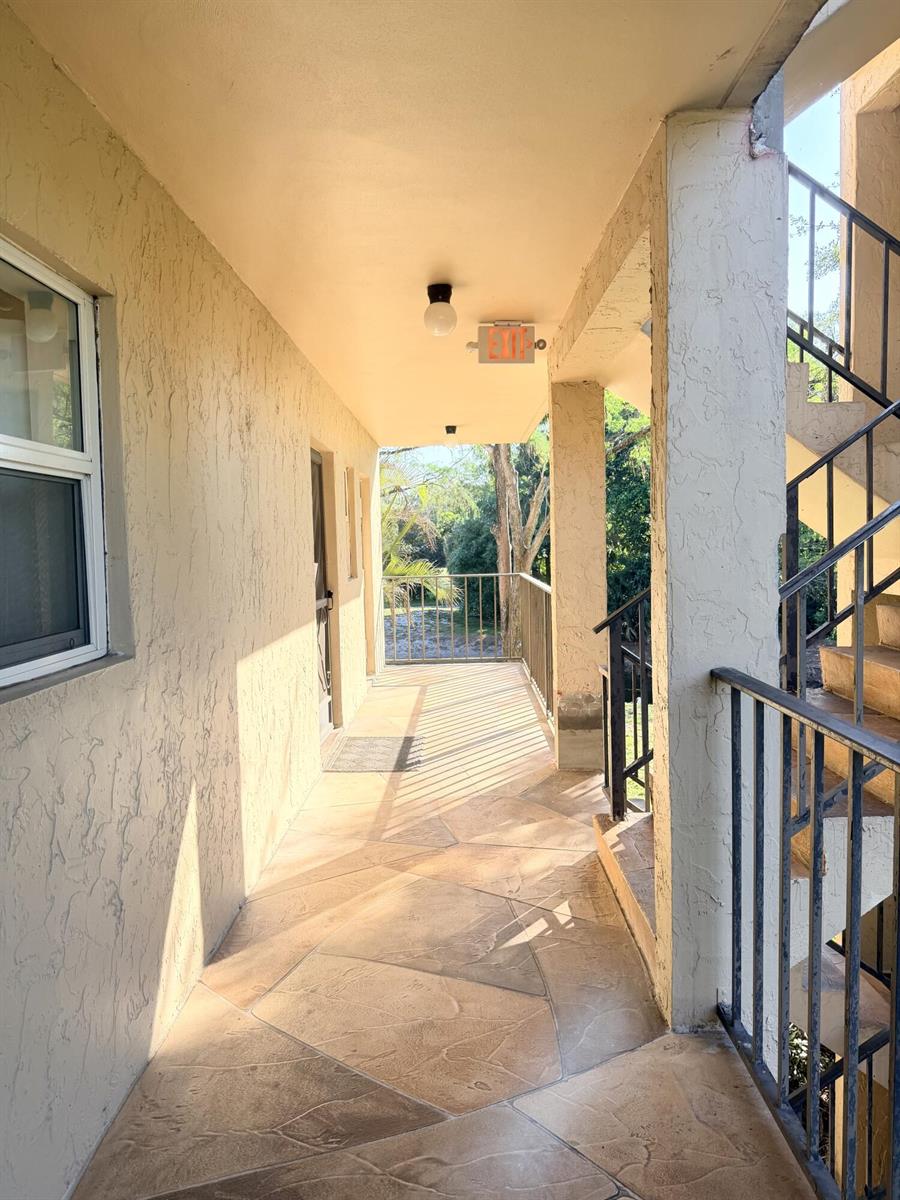 A living room features a large sectional sofa, a coffee table, and a sliding glass door — 6260 S Falls Cir Drive # 201, Lauderhill FL 33319, LAUDERHILL, FL