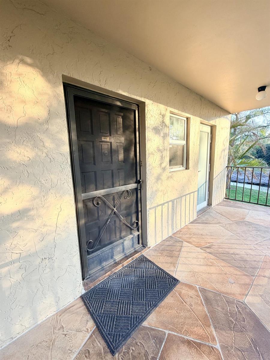 A living room with light wood flooring, a beige sectional sofa, and a dining area — 6260 S Falls Cir Drive # 201, Lauderhill FL 33319, LAUDERHILL, FL