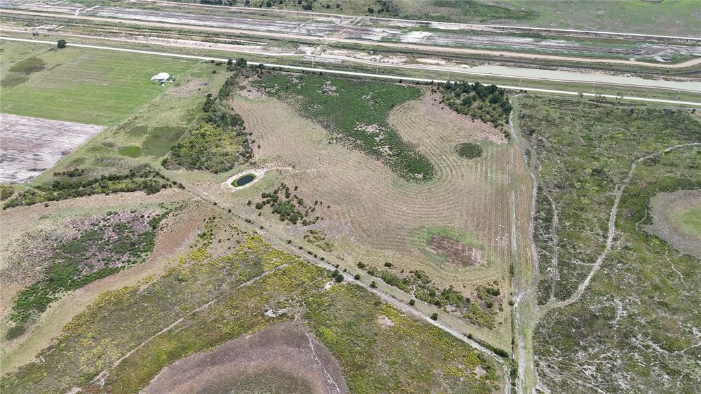 An aerial view shows a large, undeveloped plot of land with a small pond — COUNTY LINE ROAD E, FORT MEADE, FL