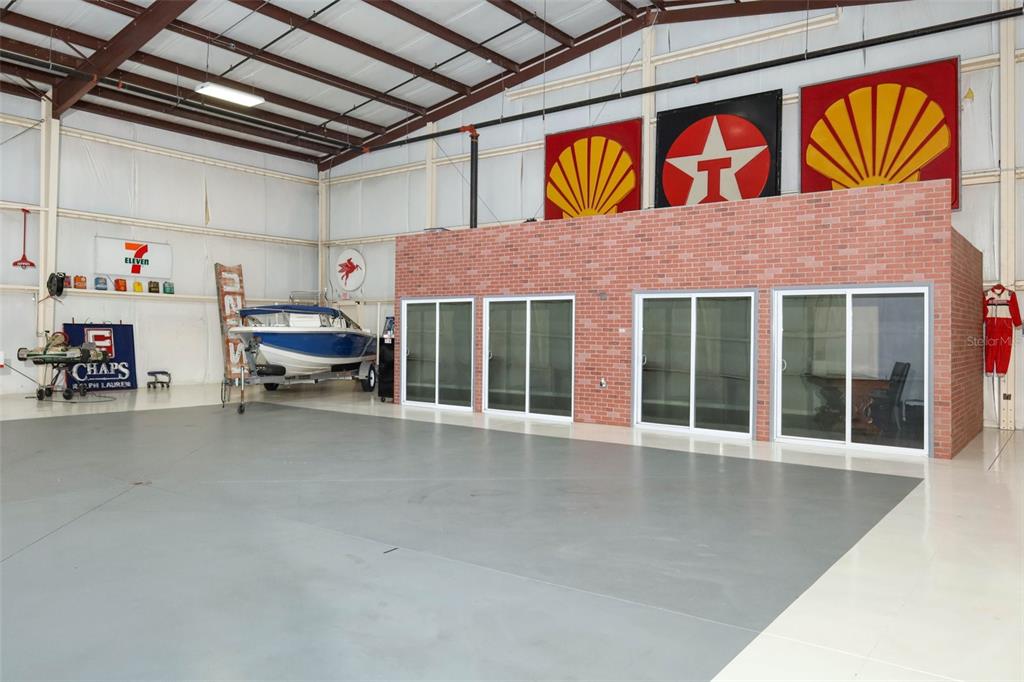 A large warehouse space features a brick-faced office structure, a boat, and vintage signage — 1312 APOPKA AIRPORT ROAD, APOPKA, FL