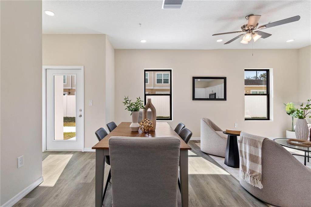 A dining area with a wooden table, grey chairs, and light wood-look flooring — 4367 CAMBIO GARDENS COURT, TAMPA, FL