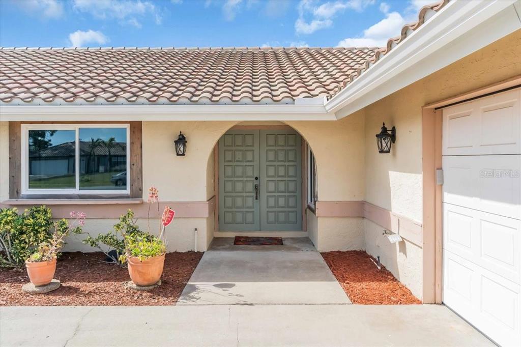 The exterior of a house features a tiled roof, double front doors, and a garage — 5061 RICHMOND TERRACE, NORTH PORT, FL