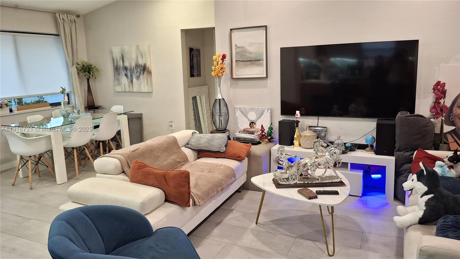 A living room features a white sofa, a coffee table with a horse sculpture, and a television — 3510 NW 33rd Ave, Miami FL 33142, MIAMI, FL