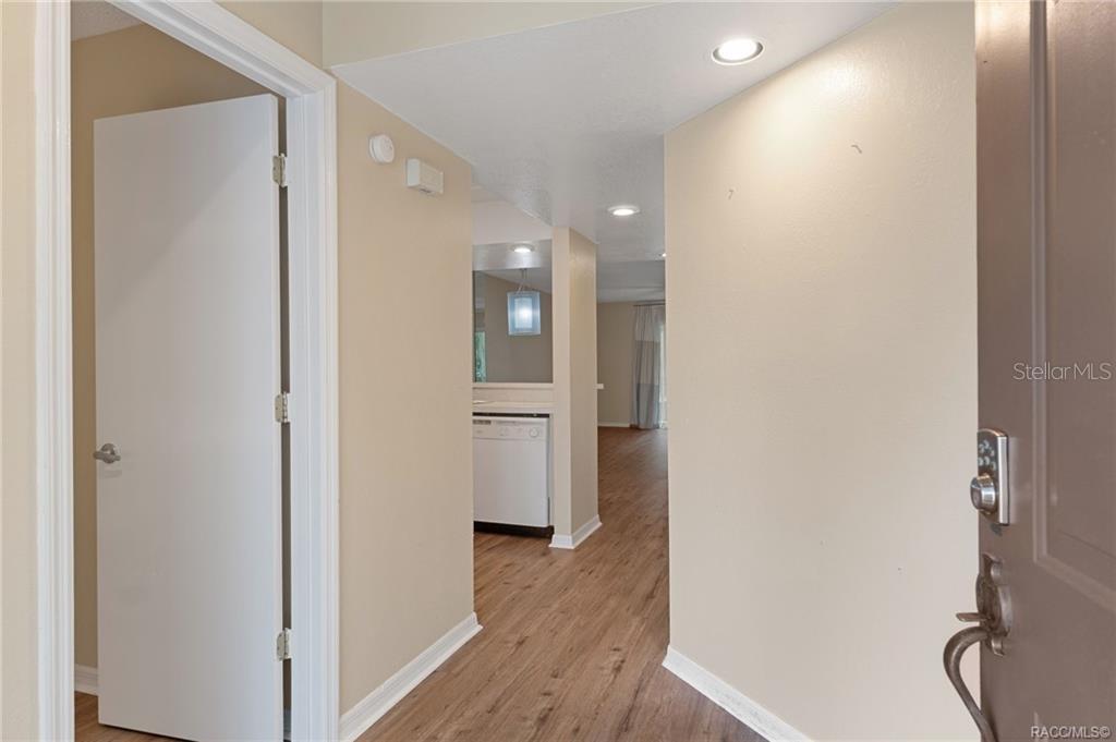 A view from an entryway looking toward a kitchen and living area with wood flooring — 1304 CYPRESS COVE COURT, INVERNESS, FL