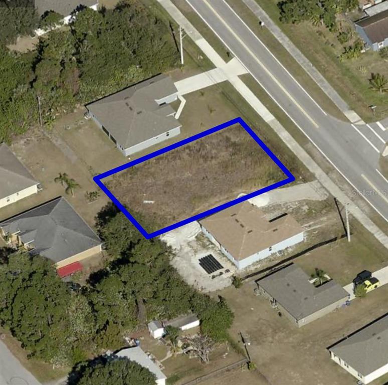 An aerial view shows a rectangular vacant lot outlined in blue between two residential houses — 2128 JUPITER BOULEVARD SW, PALM BAY, FL