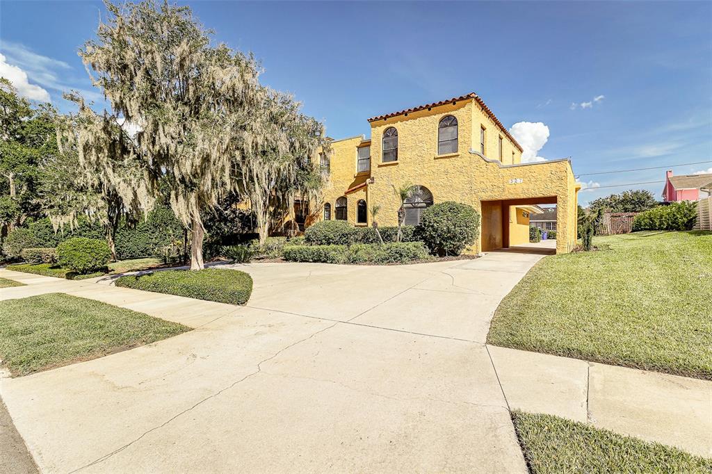 A yellow stucco house with a tiled roof and a large concrete driveway — 327 MIRAMAR ROAD, LAKELAND, FL