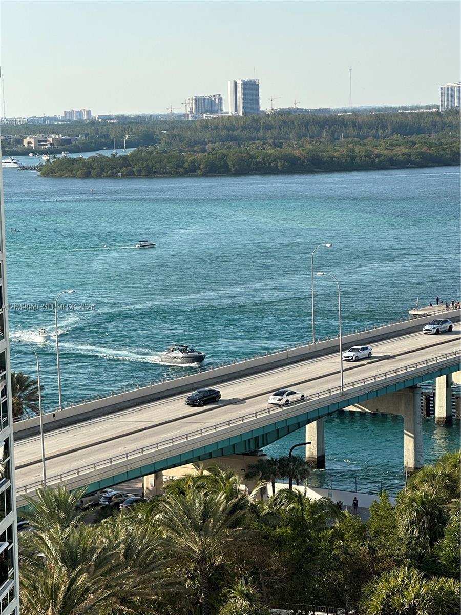 An elevated view shows a bridge crossing a bay with boats and city buildings nearby — BAL HARBOUR, FL