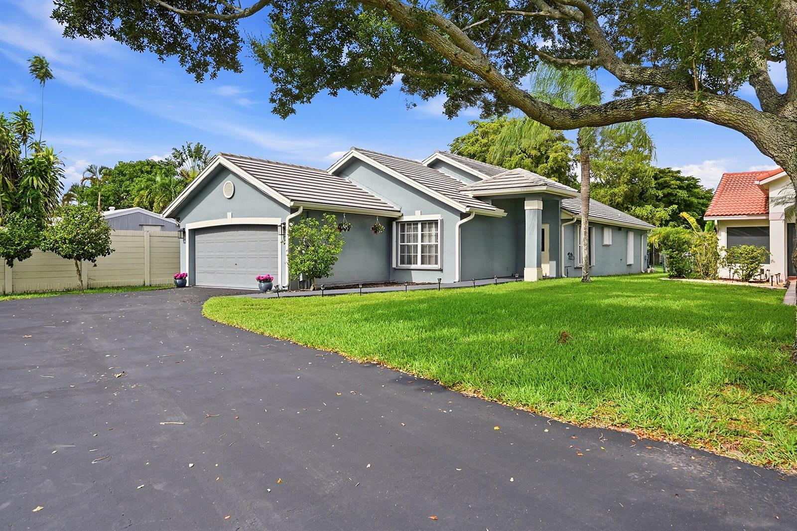 A gray single-story house with a two-car garage, tile roof, and a paved driveway — 12445 SW 7th Place, Davie FL 33325, DAVIE, FL