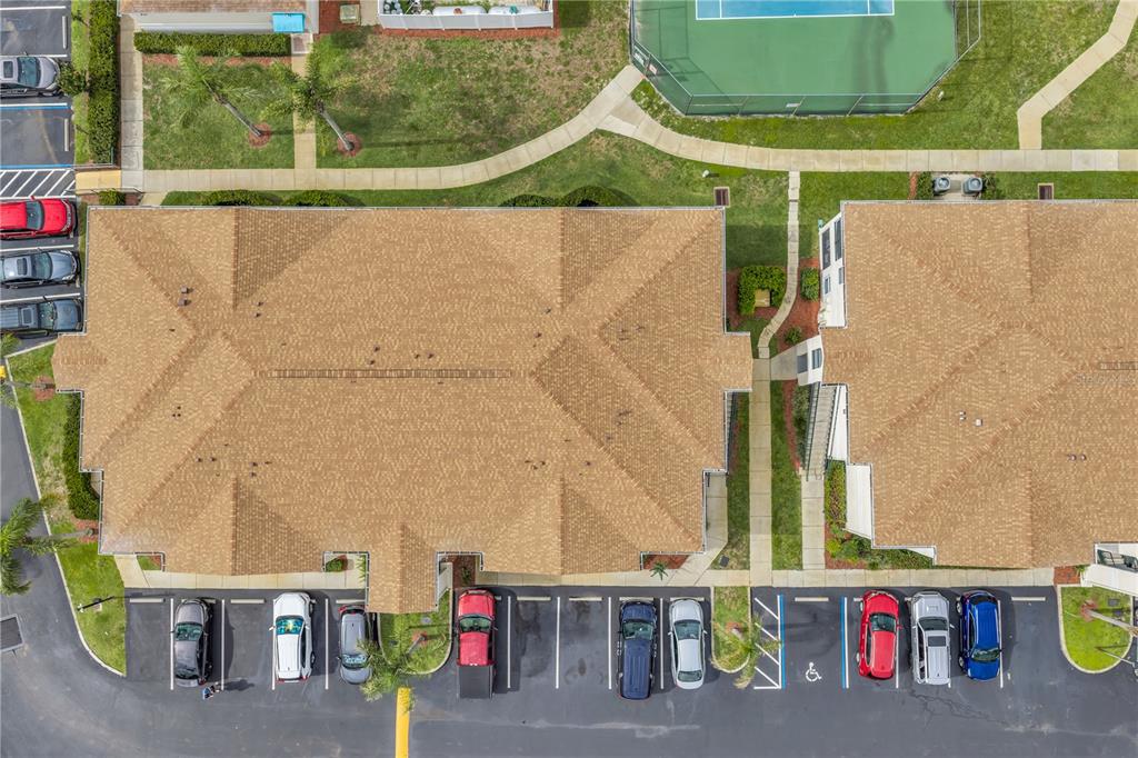 An aerial view shows two apartment buildings with brown shingled roofs and adjacent parking lots — 8810 GRAND PALMS CIRCLE UNIT B, KISSIMMEE, FL