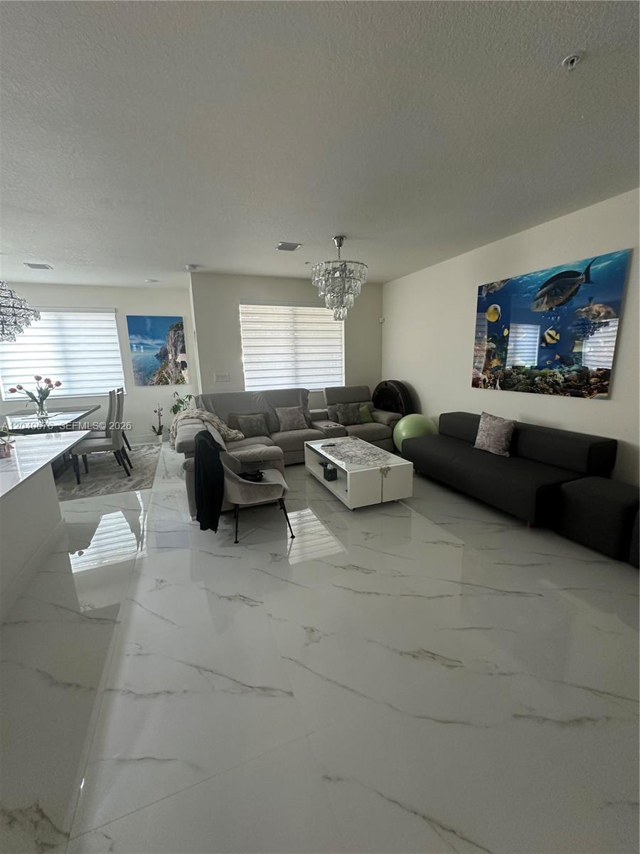 A living room features white marble floors, a grey sectional sofa, and a large fish artwork — 8001 NW 41st St # 113, Doral FL 33166, DORAL, FL