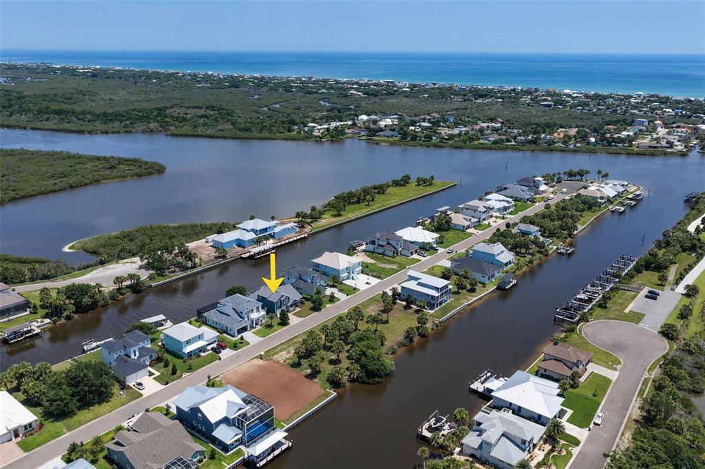 An aerial view shows a residential street with houses situated along a canal — 127 SEASIDE POINT, FLAGLER BEACH, FL