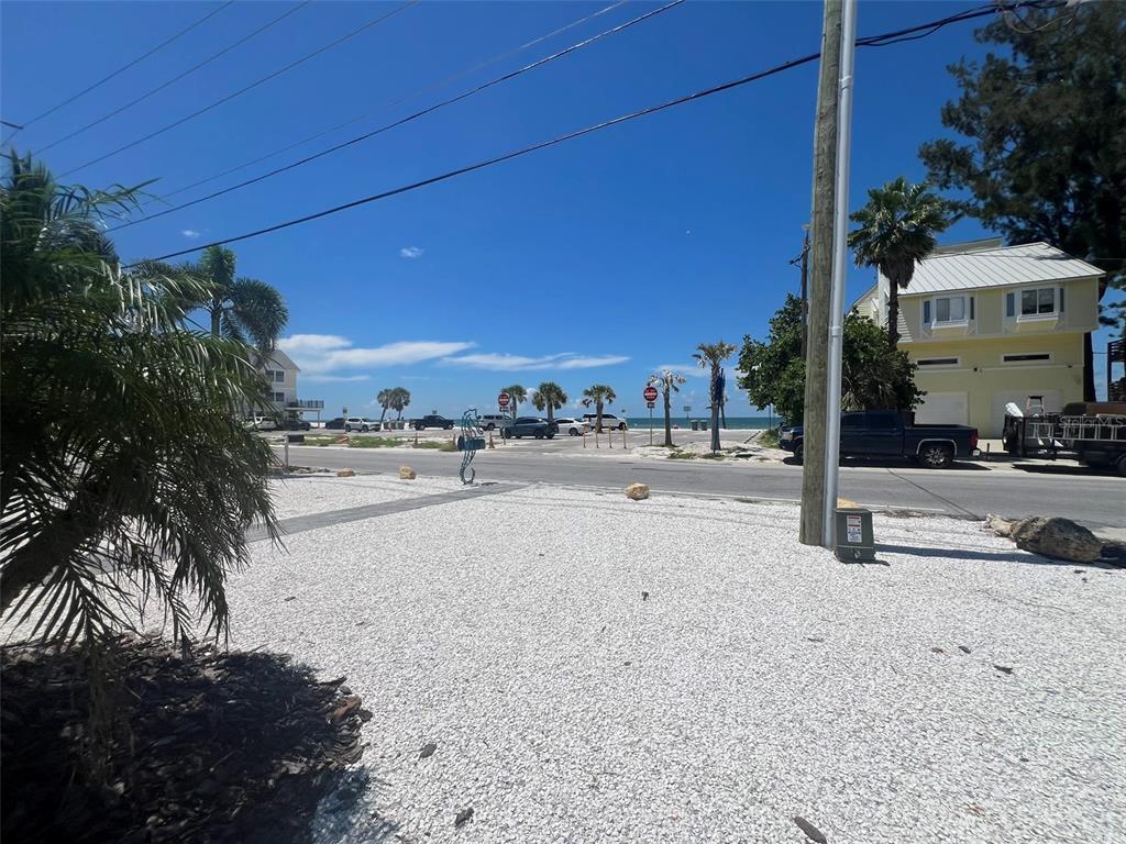 A view of a gravel lot across a street from a beach with palm trees — 5 82ND AVENUE, TREASURE ISLAND, FL