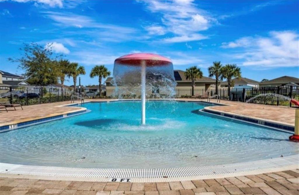 A swimming pool features a mushroom-shaped water fountain in a residential outdoor area — 244 HAMLET LOOP, DAVENPORT, FL