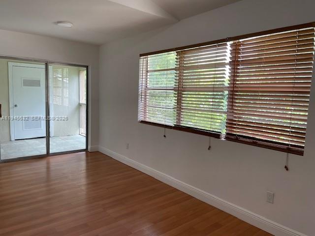 An interior room features wood-look flooring, a sliding glass door, and windows with brown blinds — 15325 SW 106th Ter # 618, Miami FL 33196, MIAMI, FL