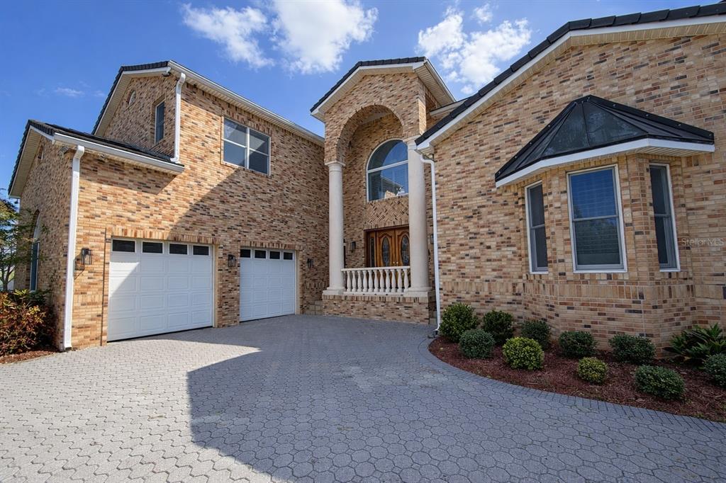 A two-story brick house features a paved driveway, a two-car garage, and a covered entryway — 441 LUCERNE AVENUE, TAMPA, FL