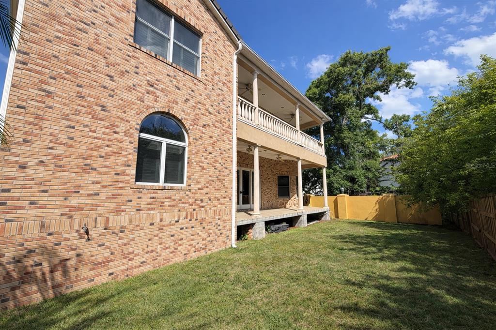 A two-story brick house with a covered back porch and a fenced grassy yard — 441 LUCERNE AVENUE, TAMPA, FL
