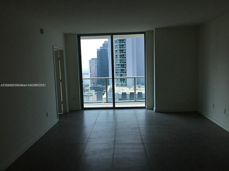 An empty room with large windows, tile flooring, and a view of city skyscrapers — 1100 S MIAMI AVE # 2903, Miami FL 33130, MIAMI, FL