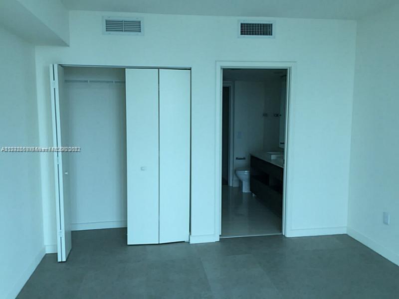 A room features a white closet with folding doors next to an open bathroom doorway — 1100 S MIAMI AVE # 2903, Miami FL 33130, MIAMI, FL