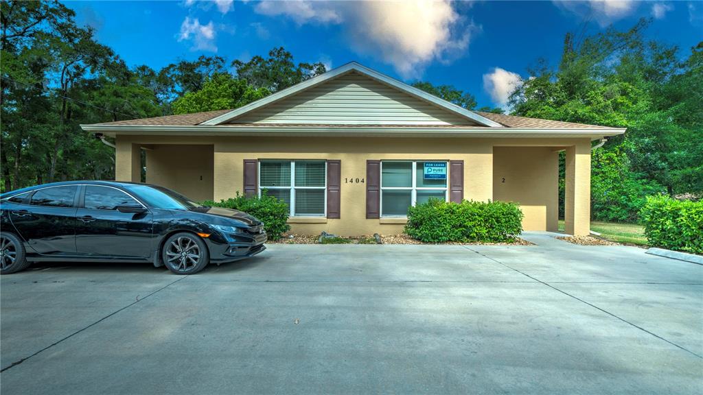 A single-story commercial building with a beige exterior, two entrances, and a parking lot — 1404 NW 18TH AVENUE, OCALA, FL