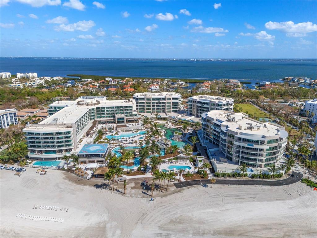 An aerial view of a large beachfront resort complex with multiple pools and surrounding buildings — 1591 GULF OF MEXICO DRIVE UNIT 512, LONGBOAT KEY, FL
