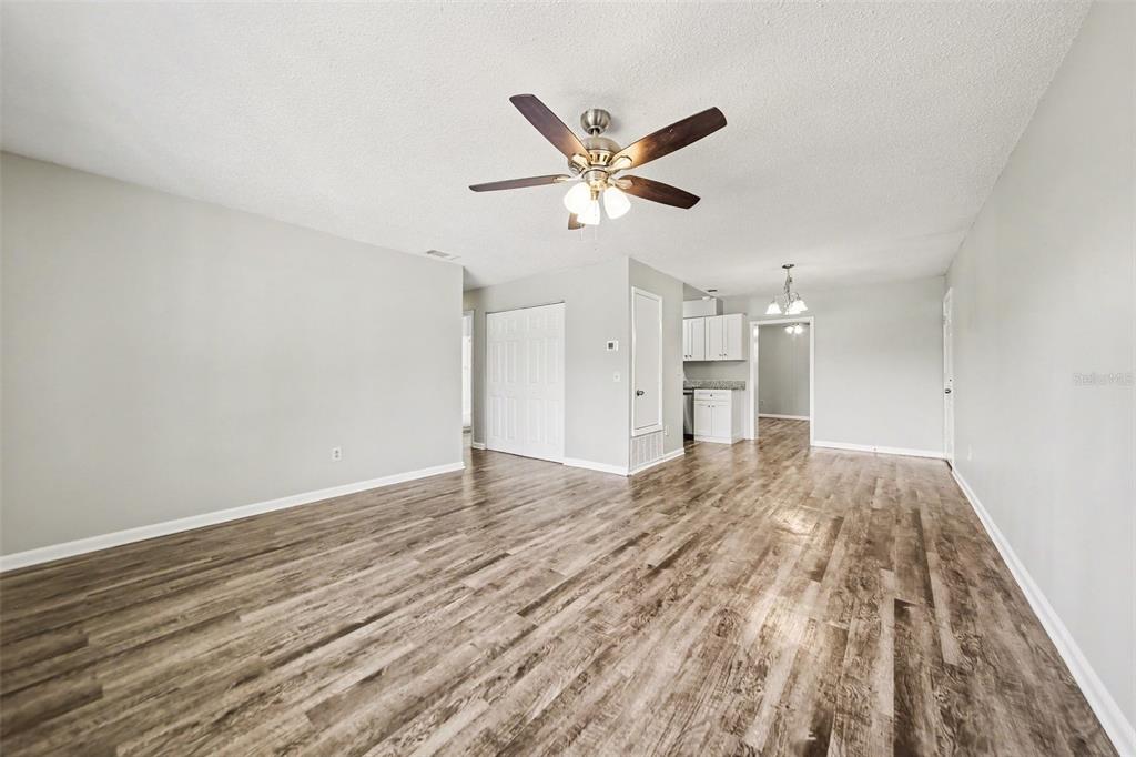 A living room with light gray walls, wood-look flooring, and a ceiling fan — 4814 BLARNEY DRIVE, ORLANDO, FL