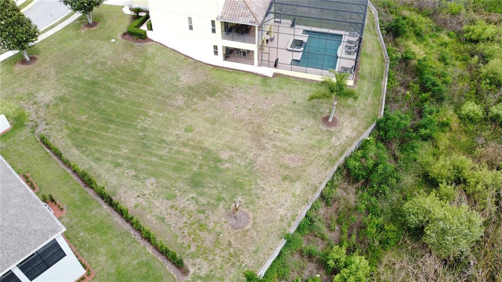 An aerial view shows a large, grassy backyard with a pool enclosure and perimeter fencing — 354 CHEROKEE AVE, HAINES CITY, FL