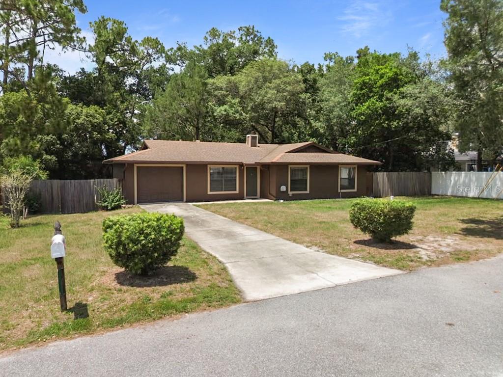 A brown single-story house with a garage and driveway sits on a grassy lot — 214 E FLOYD AVENUE, LAKE MARY, FL